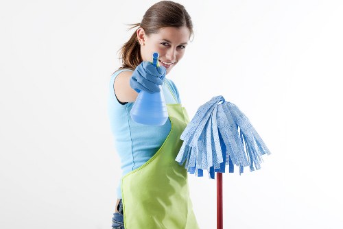Professional cleaner in Acton preparing a tidy living room