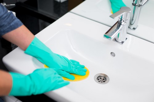 Acton cleaner vacuuming and dusting a bright residential interior
